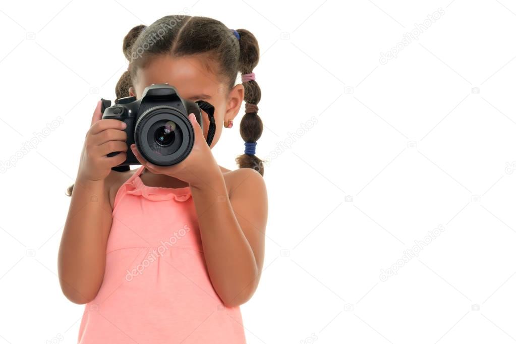 Small multiracial girl taking pictures with a professional camera