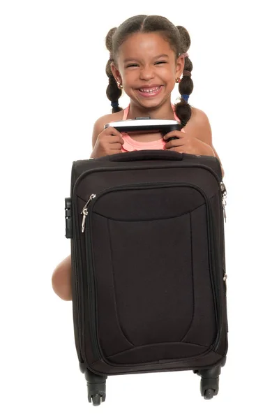 Pequeña chica multirracial con una maleta de viaje y riendo — Foto de Stock