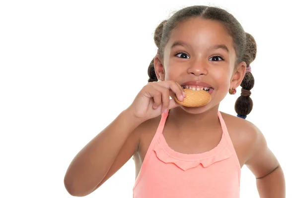 Niedliche kleine multirassische Mädchen essen einen Keks - isoliert auf weiß — Stockfoto
