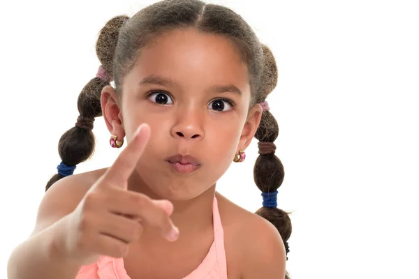 Маленька багаторасова дівчина вказує на камеру з її індексним пальцем — стокове фото