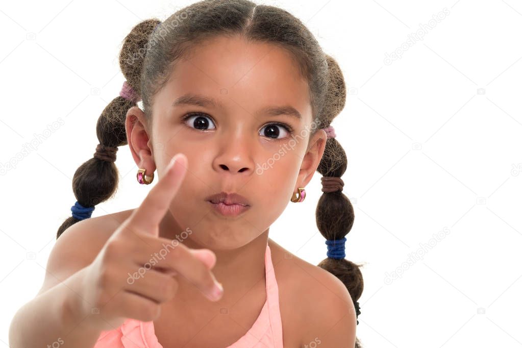 Small multiracial girl pointing to the camera with her index finger