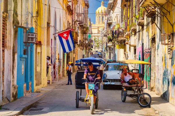 城市场面与古巴旗子和腐朽的大厦在老哈瓦那 免版税图库照片