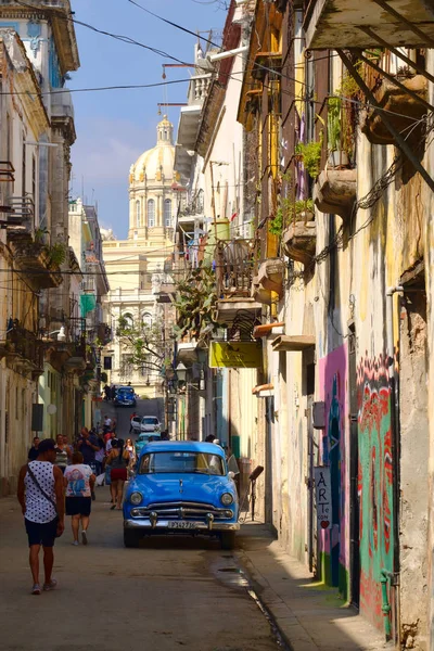 Carro velho e coloridos edifícios intemperizados em Havana Velha Imagem De Stock