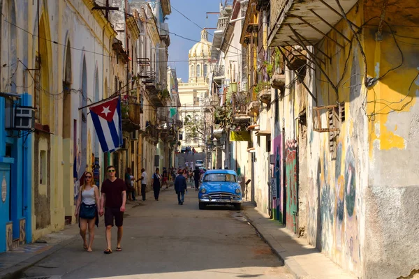 古巴国旗, 旧车和五颜六色的建筑物在老哈瓦那 图库照片