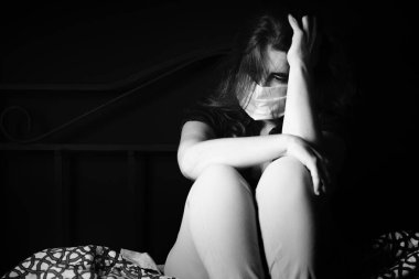 Hastalıktan korunmak için maske takan üzgün ve stresli bir kadın.