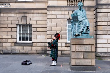 Edinburgh 'daki David Hume heykelinin yanındaki geleneksel İskoç etekli gayda çalan adam.