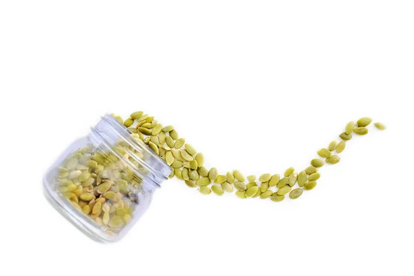 Dýňová semínka vytékající ze sklenice — Stock fotografie