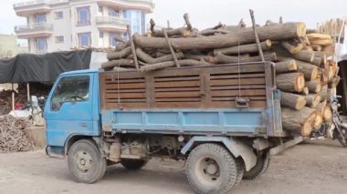 Kamyon ve kimliği belirsiz kişiler 2018 yılında Mazar-i-Şerif, Kuzey Afganistan 'daki bir kömür pazarında.