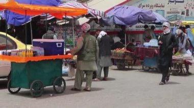 2018 'de Mazar-i-Şerif, Kuzey Afganistan' daki bir pazarda kimliği belirsiz kişiler.