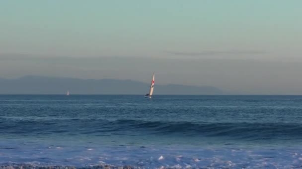 カリフォルニア州サンタクルス アメリカ 2018年の日没時にツインレイクスビーチから見たセーリングヨット — ストック動画