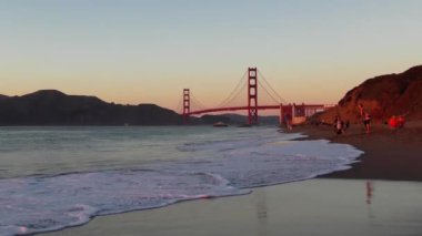 San Francisco, Kaliforniya 'daki Baker Sahili' nde kimliği belirsiz insanlar. Arka plandaki Golden Gate Köprüsü, 2018.