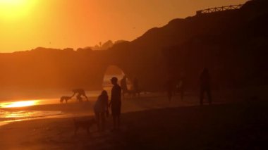 Pasifik Okyanusu 'nda gün batımında kimliği belirsiz insanlar, Santa Cruz, California, ABD, yaklaşık Ekim 2018.