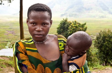 BUNYONYI Gölü, UGANDA - 21 Ekim 2012 'de Uganda' daki Bunyonyi Gölü 'nde kimliği belirsiz Batwa kadını ve çocuğu. Domuzlar ormanlarda yaşayan antik insanlardır, 