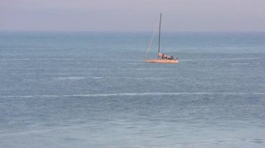 Pasifik Okyanusu 'nda yelkenli bir yat, Santa Cruz Sahili Boardwalk' tan gün batımında, Santa Cruz County, Kaliforniya, ABD 'deki Monterey Körfezi' nde görülüyor.