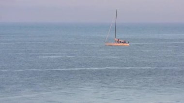 Pasifik Okyanusu 'nda yelkenli bir yat, Santa Cruz Sahili Boardwalk' tan gün batımında, Santa Cruz County, Kaliforniya, ABD 'deki Monterey Körfezi' nde görülüyor.