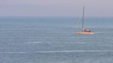 Pasifik Okyanusu 'nda yelkenli bir yat, Santa Cruz Sahili Boardwalk' tan gün batımında, Santa Cruz County, Kaliforniya, ABD 'deki Monterey Körfezi' nde görülüyor.