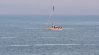 Pasifik Okyanusu 'nda yelkenli bir yat, Santa Cruz Sahili Boardwalk' tan gün batımında, Santa Cruz County, Kaliforniya, ABD 'deki Monterey Körfezi' nde görülüyor.