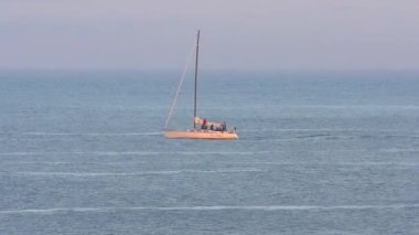 Pasifik Okyanusu 'nda yelkenli bir yat, Santa Cruz Sahili Boardwalk' tan gün batımında, Santa Cruz County, Kaliforniya, ABD 'deki Monterey Körfezi' nde görülüyor.