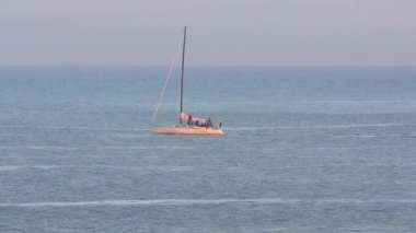 Pasifik Okyanusu 'nda yelkenli bir yat, Santa Cruz Sahili Boardwalk' tan gün batımında, Santa Cruz County, Kaliforniya, ABD 'deki Monterey Körfezi' nde görülüyor.