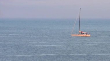Pasifik Okyanusu 'nda yelkenli bir yat, Santa Cruz Sahili Boardwalk' tan gün batımında, Santa Cruz County, Kaliforniya, ABD 'deki Monterey Körfezi' nde görülüyor.