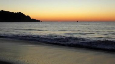 Su sıçratan deniz dalgaları üzerinde muhteşem renkli gün batımı