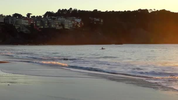 美丽多彩的落日笼罩着海湾 背靠着皮划艇的男子 — 图库视频影像