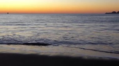 Su sıçratan deniz dalgaları üzerinde muhteşem renkli gün batımı