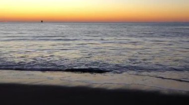 Su sıçratan deniz dalgaları üzerinde muhteşem renkli gün batımı