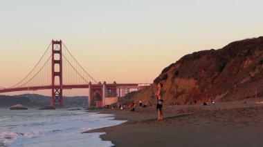 San Francisco, Kaliforniya 'daki Baker Sahili' nde kimliği belirsiz insanlar. Arka plandaki Golden Gate Köprüsü, 2018.