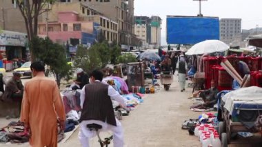 2018 'de Mazar-i-Şerif, Kuzey Afganistan' daki bir pazarda kimliği belirsiz kişiler.