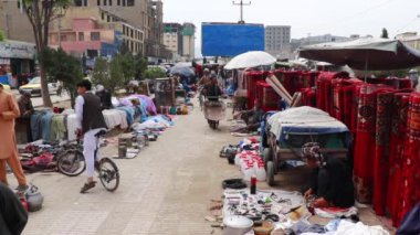 2018 'de Mazar-i-Şerif, Kuzey Afganistan' daki bir pazarda kimliği belirsiz kişiler.