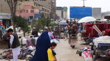 2018 'de Mazar-i-Şerif, Kuzey Afganistan' daki bir pazarda kimliği belirsiz kişiler.