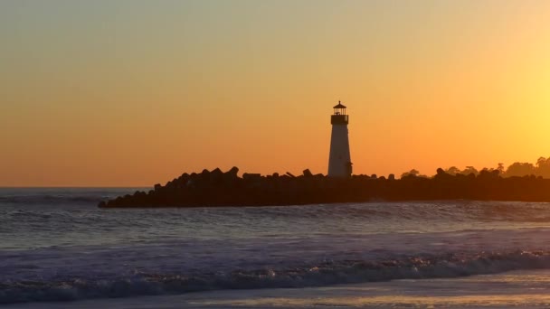 サンタクルス防波堤 別名ウォルトン灯台 アメリカ合衆国カリフォルニア州サンタクルスのツインレイクスビーチから見える日没時の灯台 — ストック動画