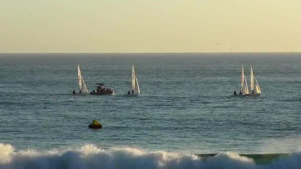 2018年米国カリフォルニア州サンタクルーズで日没時にツインレイクスビーチから見られるヨットをセーリング — ストック動画
