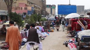 2018 'de Mazar-i-Şerif, Kuzey Afganistan' daki bir pazarda kimliği belirsiz kişiler.