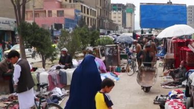 2018 'de Mazar-i-Şerif, Kuzey Afganistan' daki bir pazarda kimliği belirsiz kişiler.