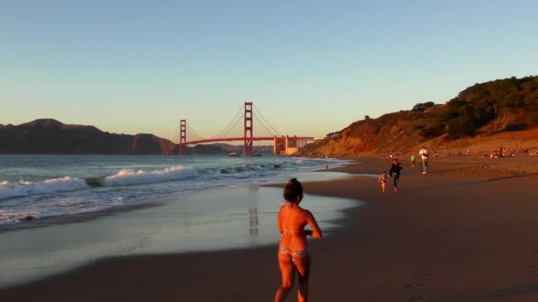 2018年加州旧金山贝克海滩的不明身份者背景为金门大桥 — 图库视频影像