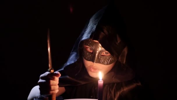 Une druide satanique avec un couteau, un livre et une bougie. 4K UHD — Video