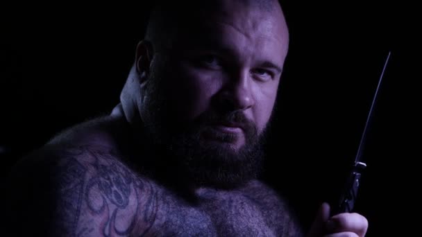 Careca tatuado gangster muscular barbudo com uma faca. 4K UHD — Vídeo de Stock