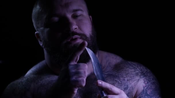 Glatzköpfiger, bärtiger, muskulöser Gangster mit Messer. 4k uhd — Stockvideo