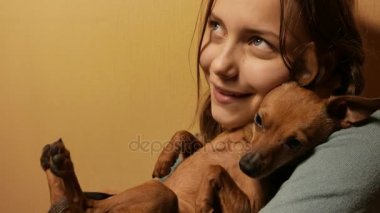 Genç kız having oyunculuk ile onun küçük oyuncak terrier köpek gülümsüyor. 4k Uhd.