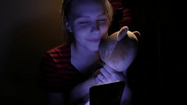 Genç kız evde telefonla ona kötü bir oyuncak ayı ve küçük köpek ile sohbet. 4k Uhd