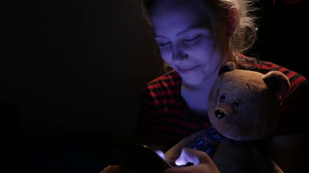 Девочка-подросток болтает по телефону дома, в плохом настроении с игрушечным медведем и собачкой. 4K UHD — стоковое видео