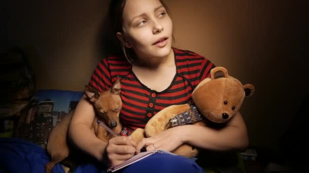 Adolescente scrivere diario a casa nel suo male con un orso giocattolo e cagnolino. 4K UHD — Video Stock