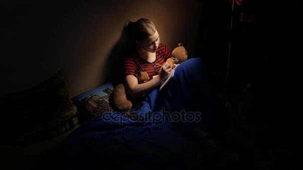 Genç yazma günlüğüne evde onu kötü bir oyuncak ayı ve küçük köpecik. 4k Uhd — Stok video