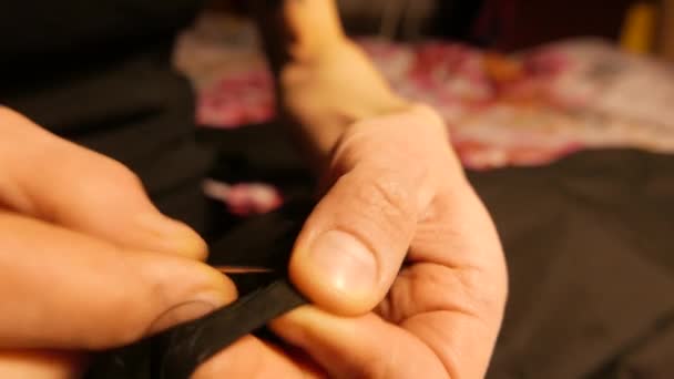 Руки молодого портного, который шьет иглой. 4K UHD — стоковое видео