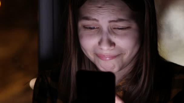 Tiener meisje met een smartphone op venster, chatten en praten. 4k Uhd. — Stockvideo