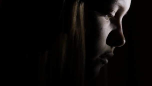 7Gros plan portrait d'une adolescente déprimée dans le noir. 4K UHD .