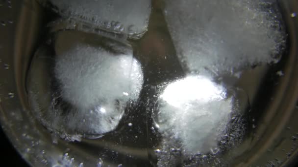 Ігристе водяне скло тане кубиками льоду. 4K UHD — стокове відео