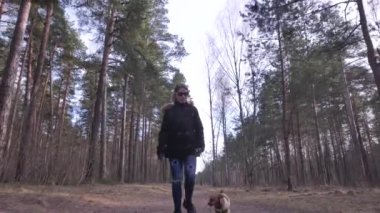 Onu köpekle oynamayı ve kamera doğru yürüyen bir kadın.